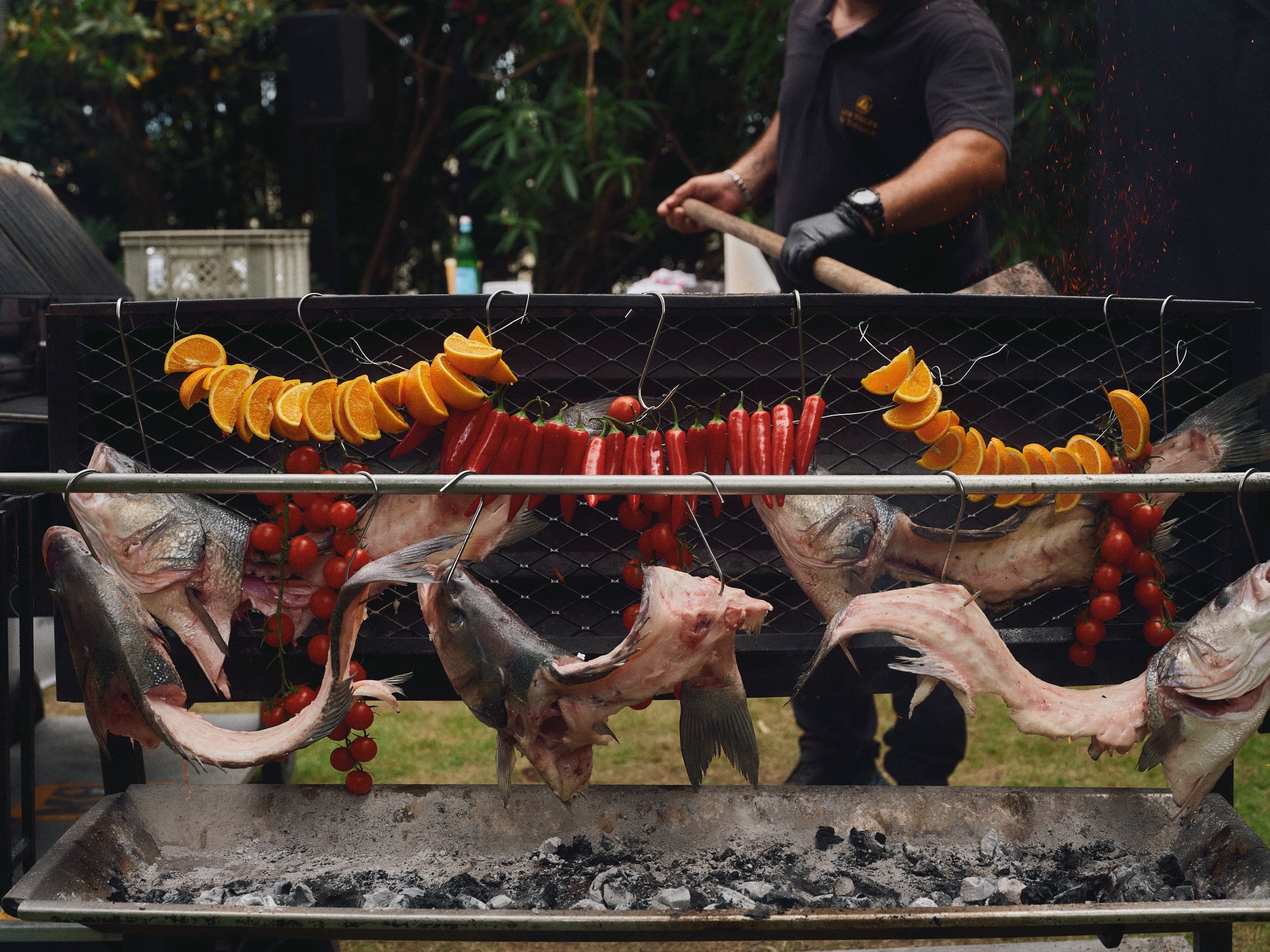 Fish and vegetables cooking over an outdoor fire