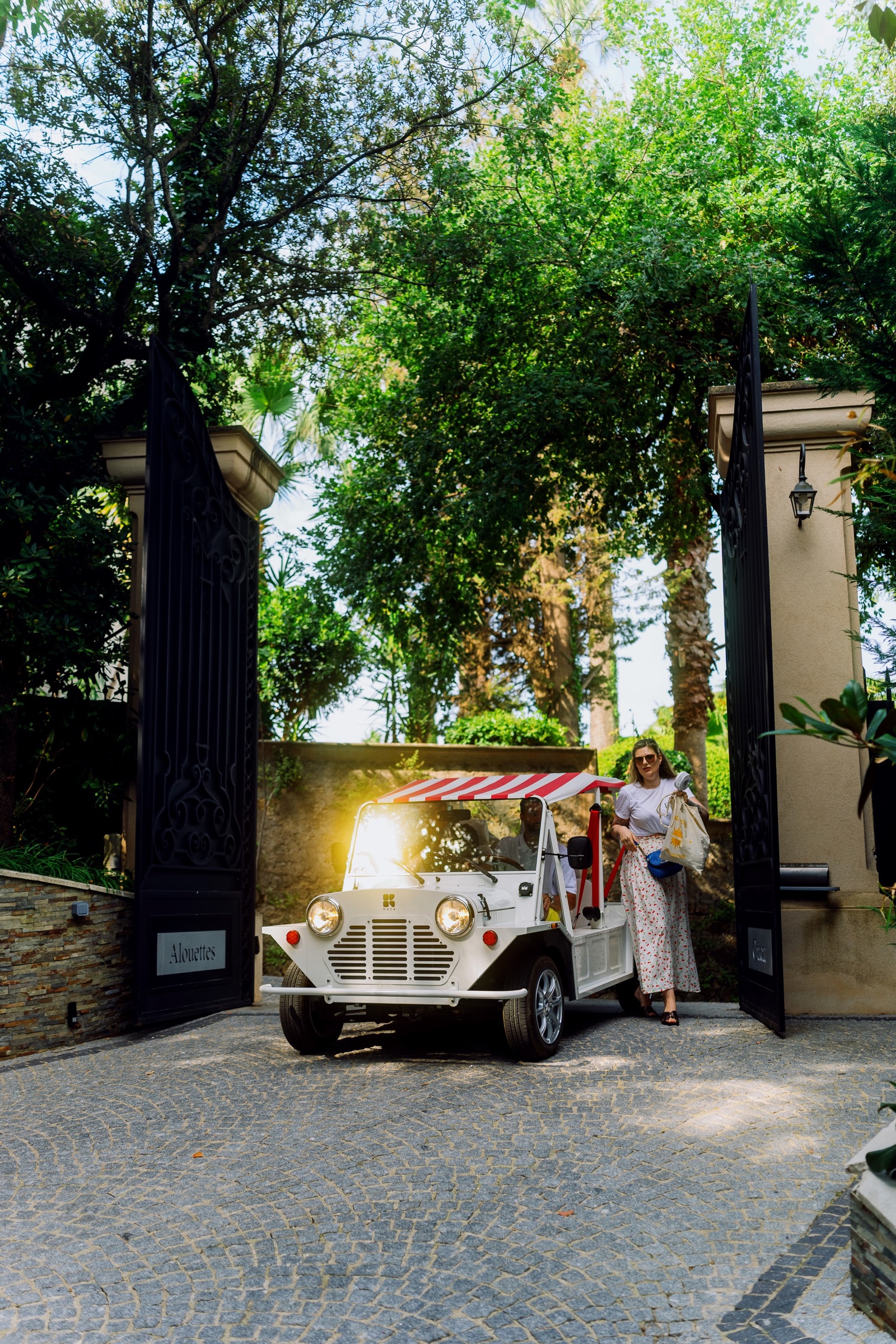 Guests arriving through the gates in an open-top car