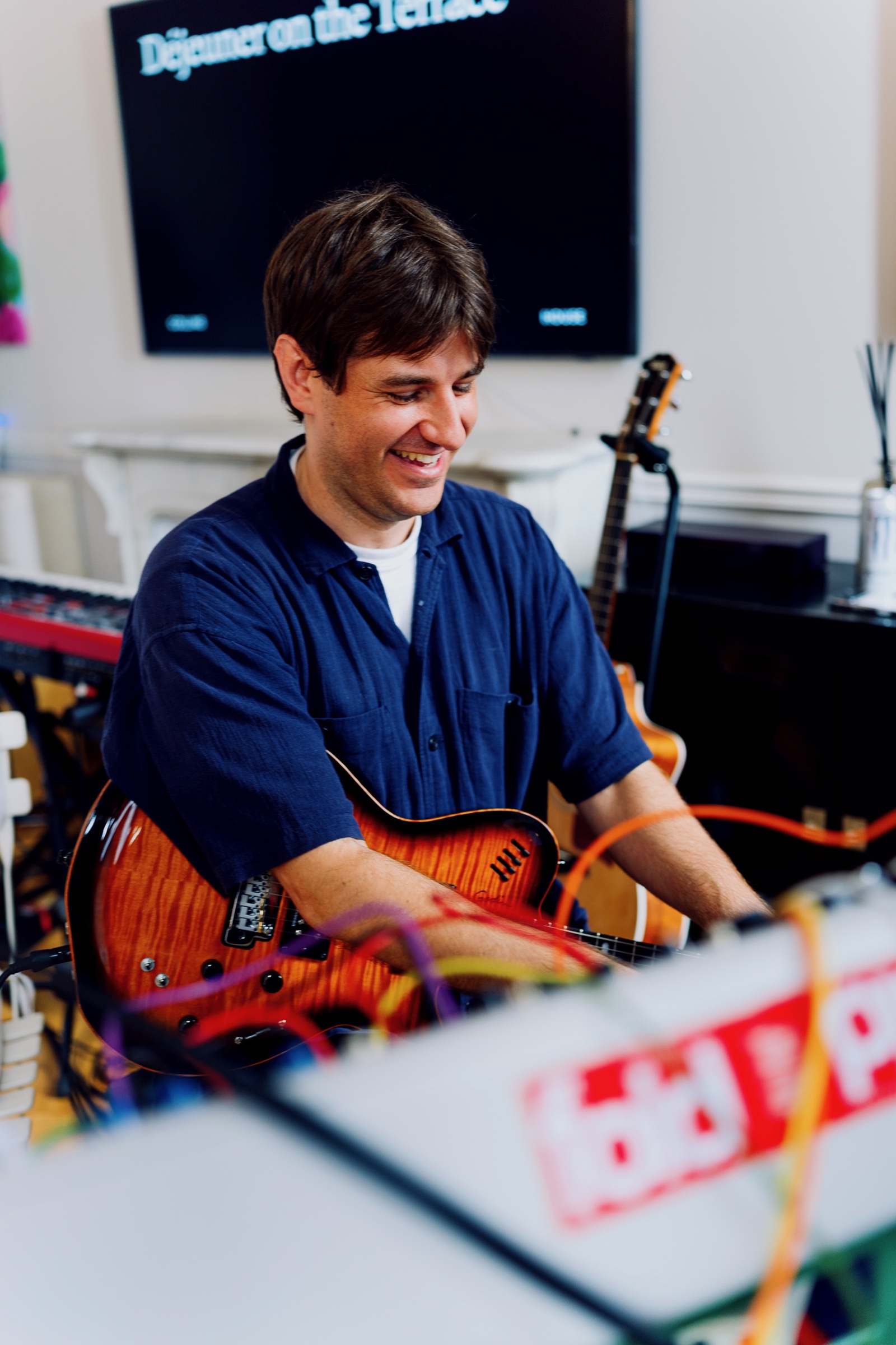 A musician playing guitar inside COLLINS House