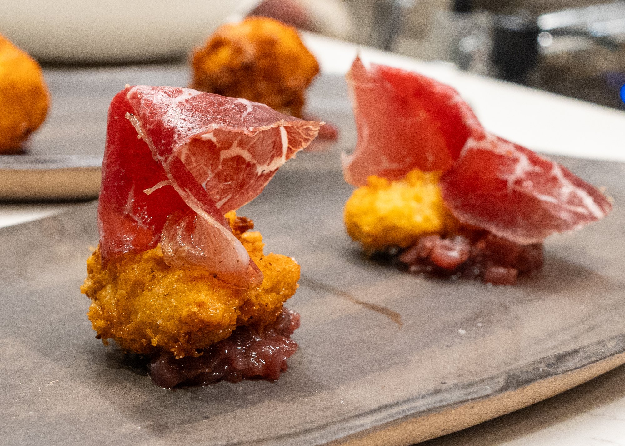 Small bites topped with cured meat