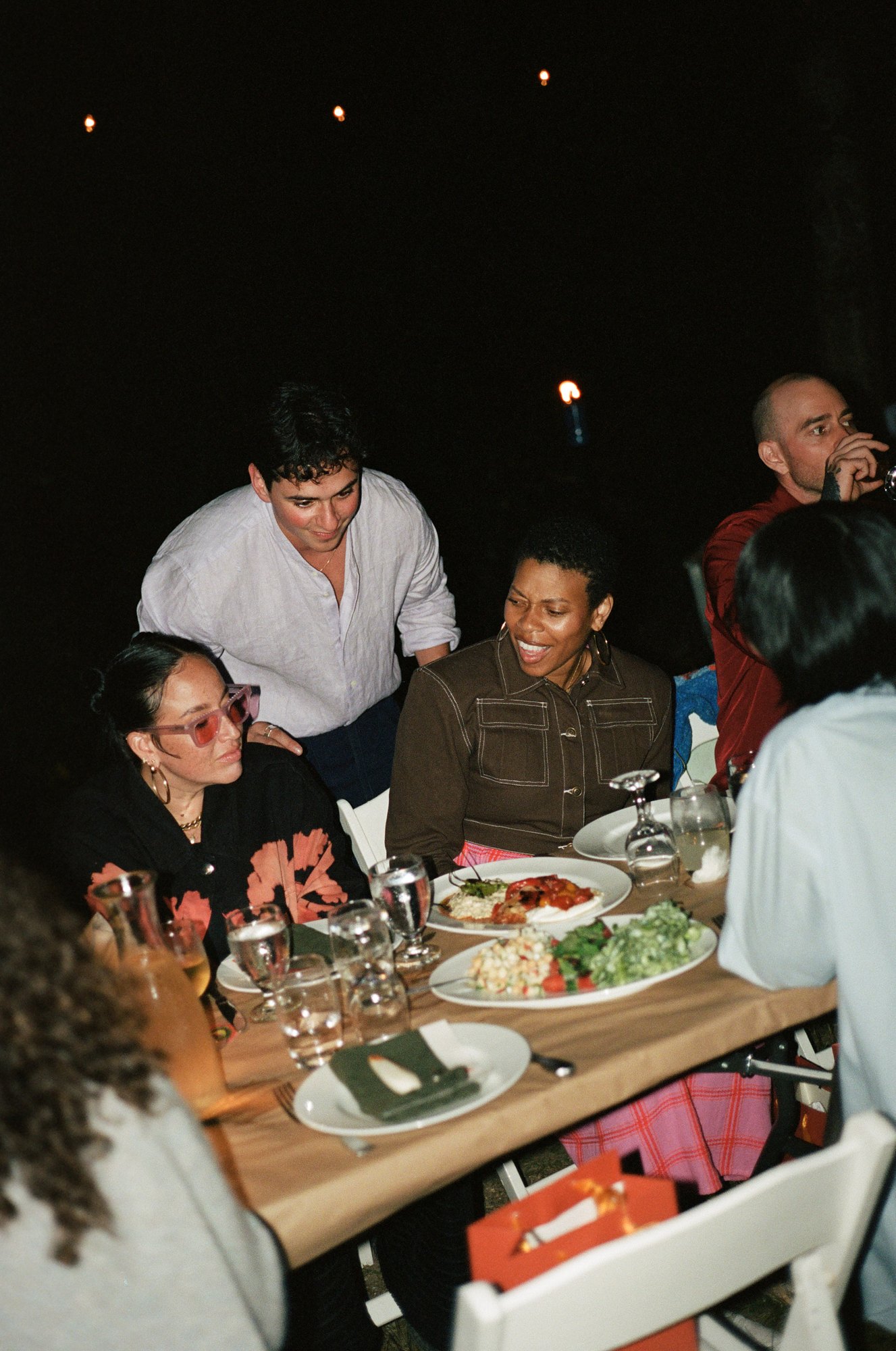 Eron serving guests at the outdoor dinner table