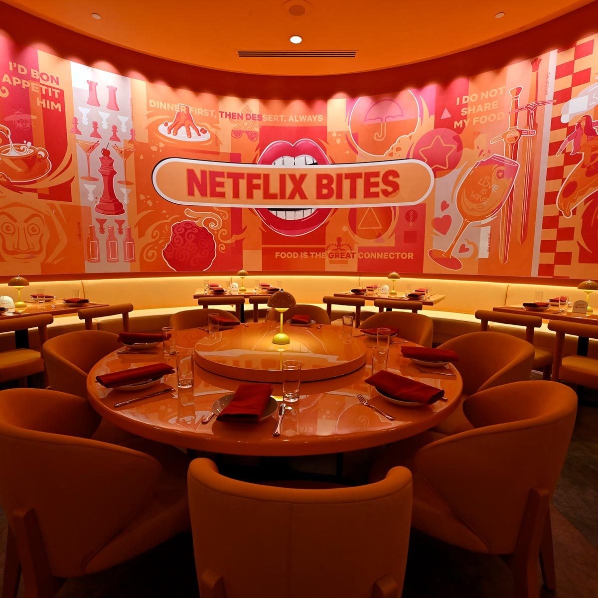 Round dining tables beneath colorful Netflix Bites artwork