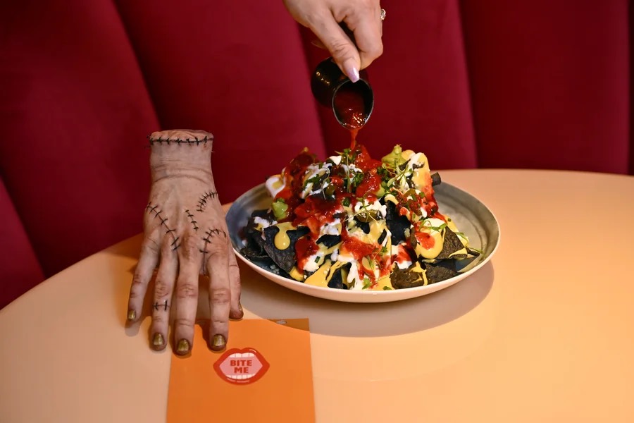 A Wednesday-inspired dish served beside a Thing hand prop at Netflix Bites