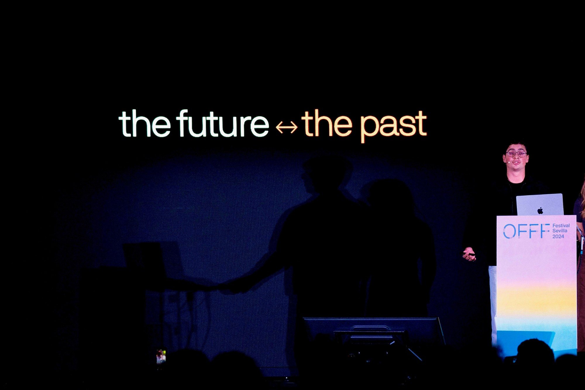 Eron presenting a slide reading “the future ↔ the past” at OFFF Sevilla