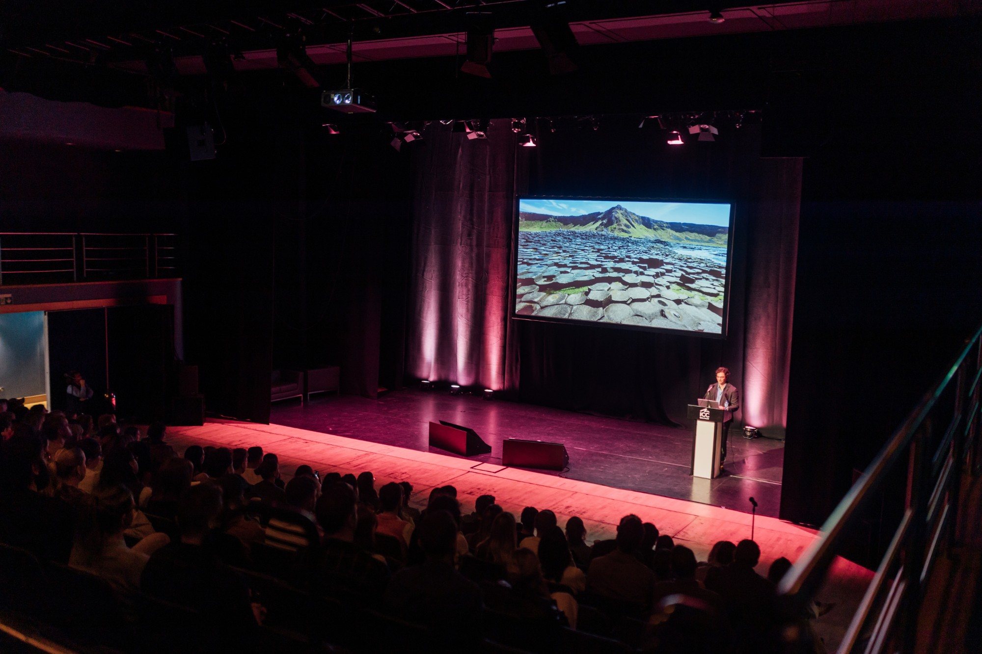 A full audience at ICC Belfast watching a slide of the Giant’s Causeway