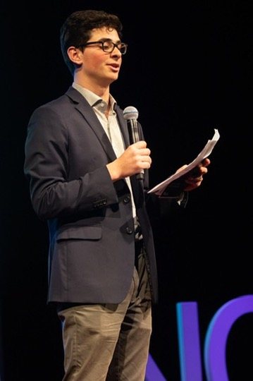Eron reading from notes on stage