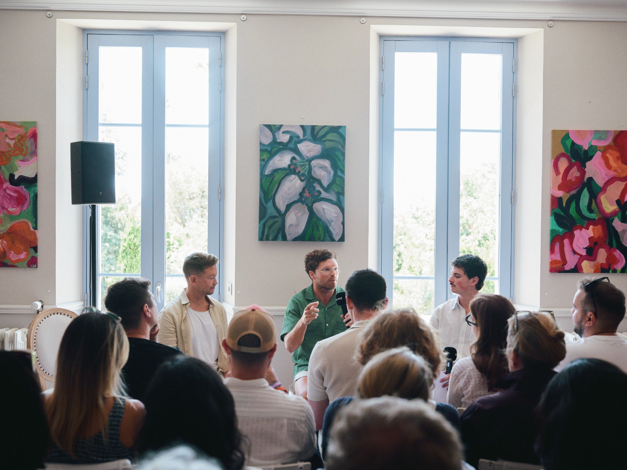 Eron moderating a panel in a sunlit room at COLLINS House
