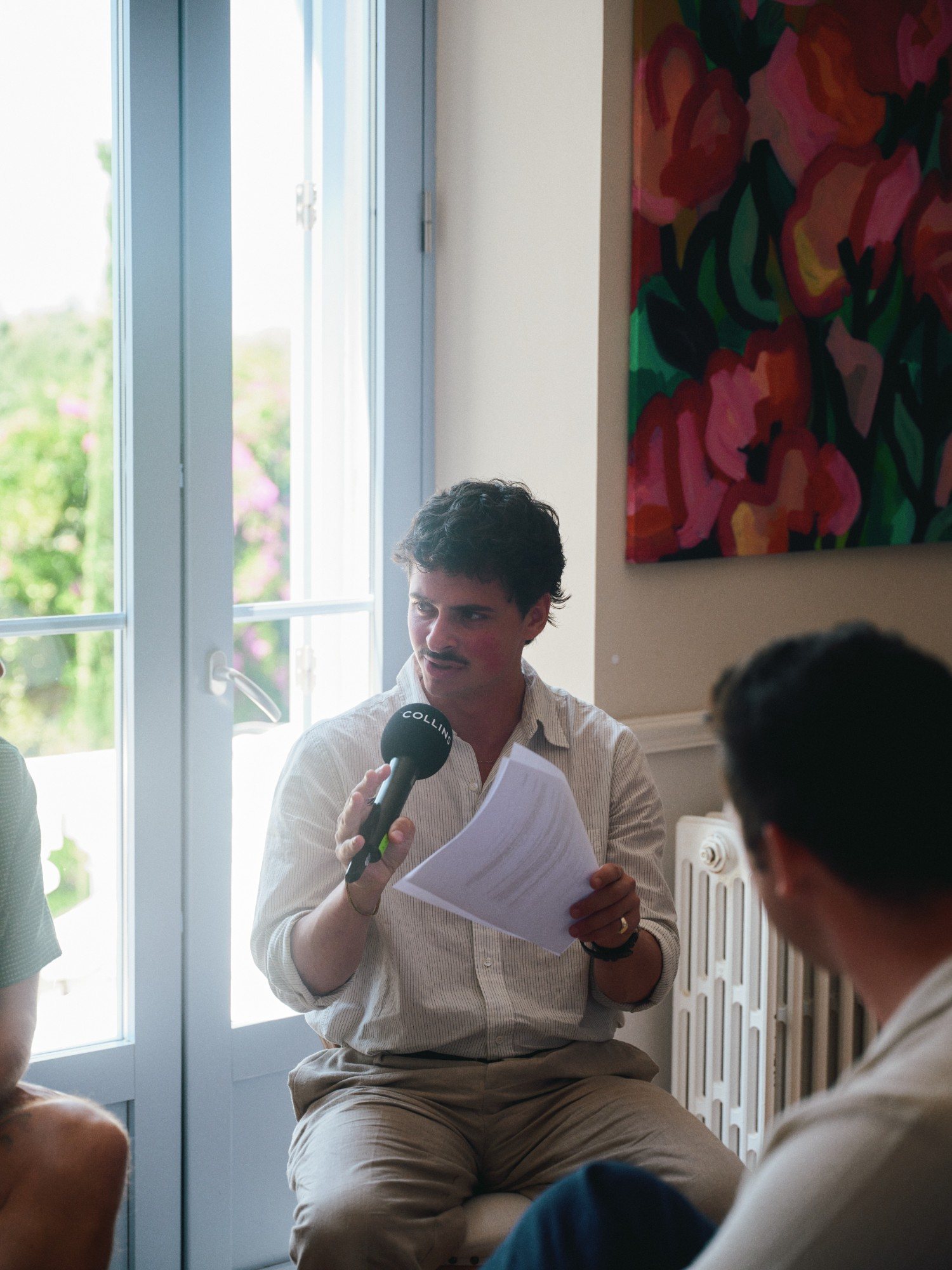 Eron reading a question from his notes into a COLLINS microphone