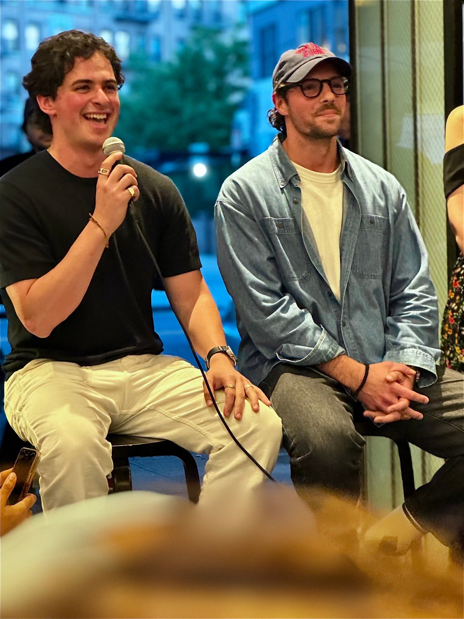 Eron laughing with a fellow panelist during an evening conversation in New York