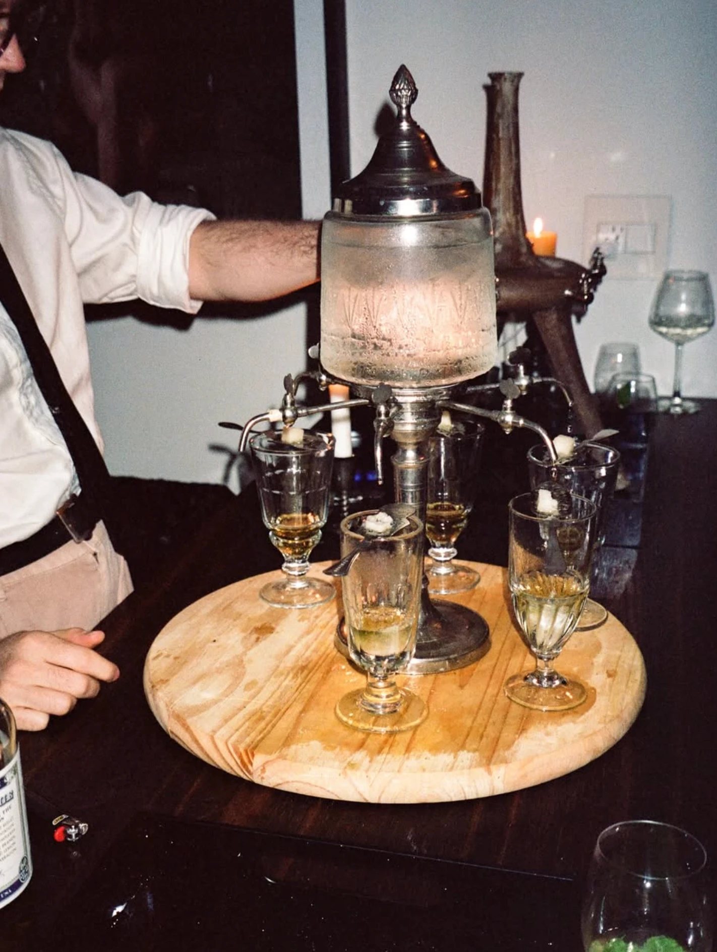 An absinthe fountain dripping water over sugar into glasses