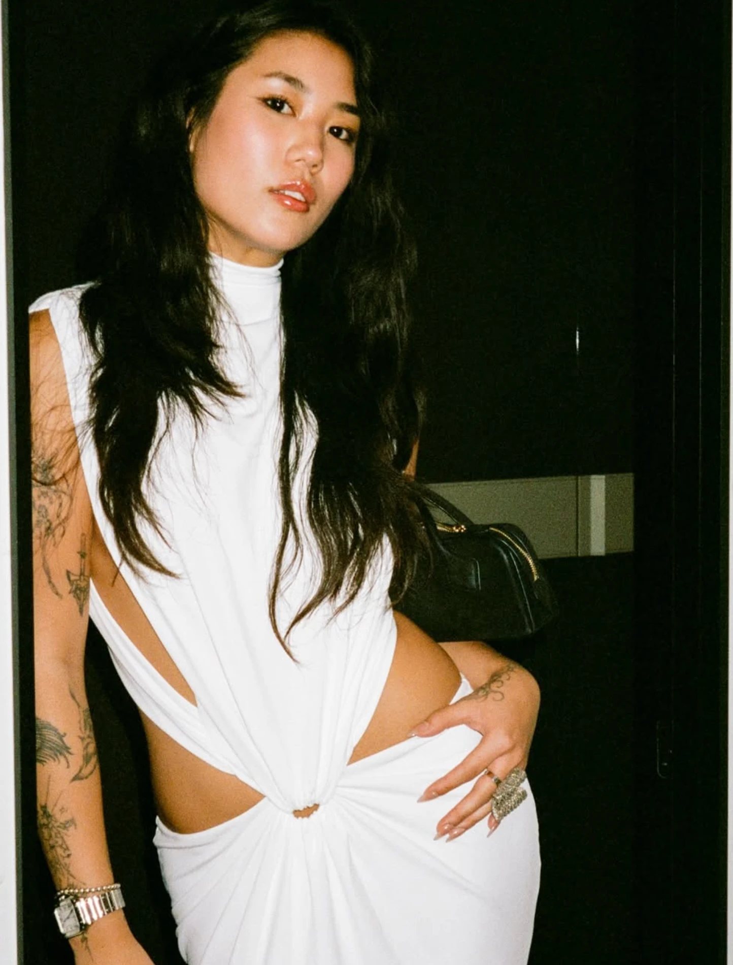 A guest in a white dress posing in a doorway