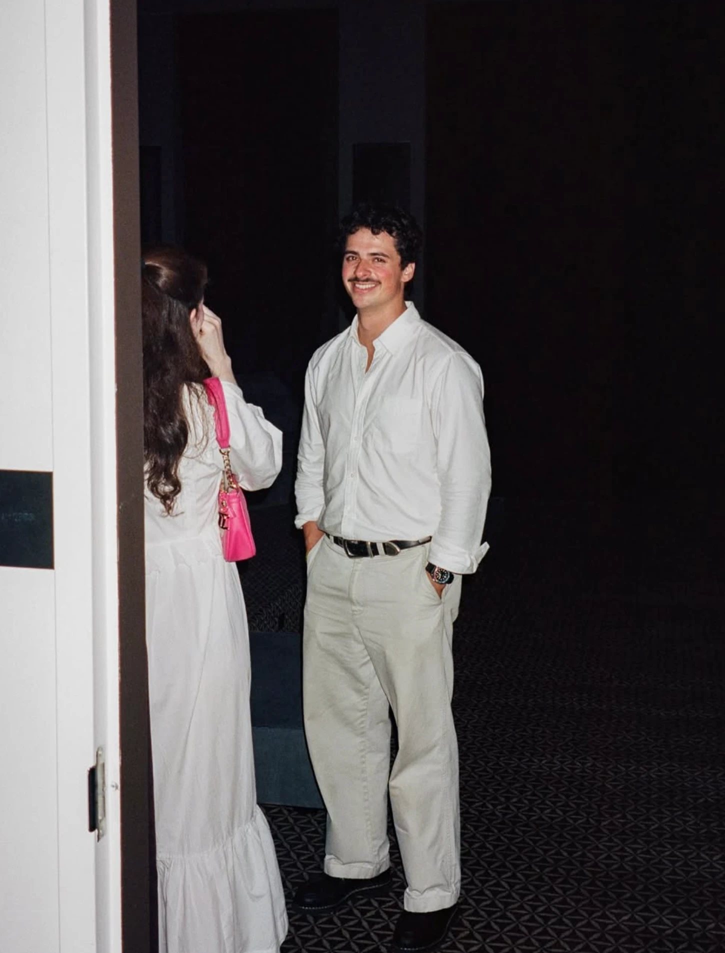 A guest smiling in a dark doorway