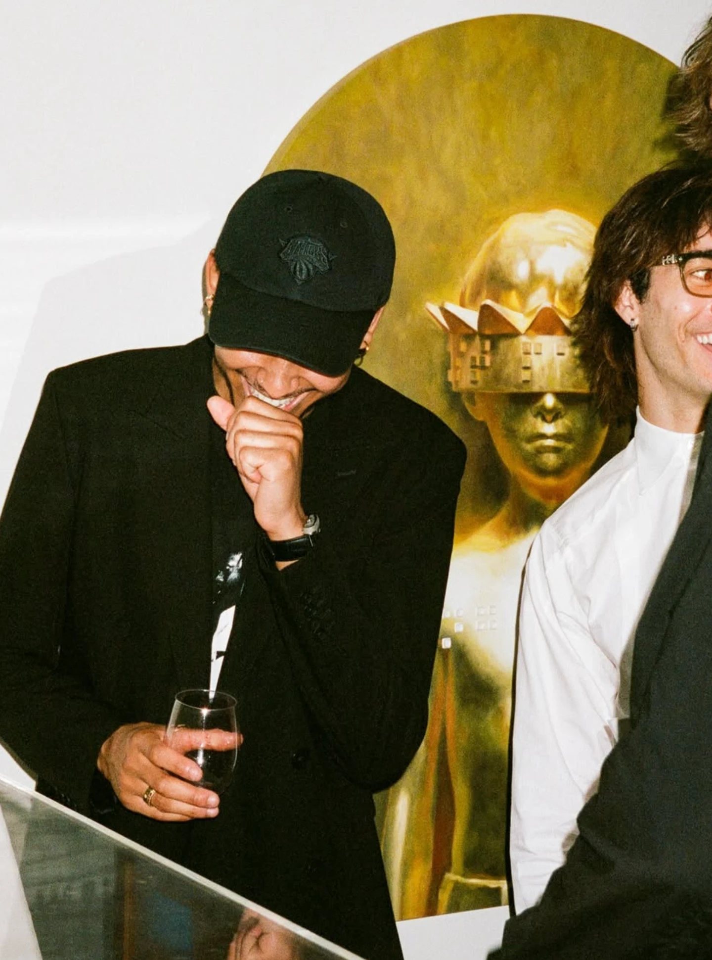 A guest laughing in front of a gold painting