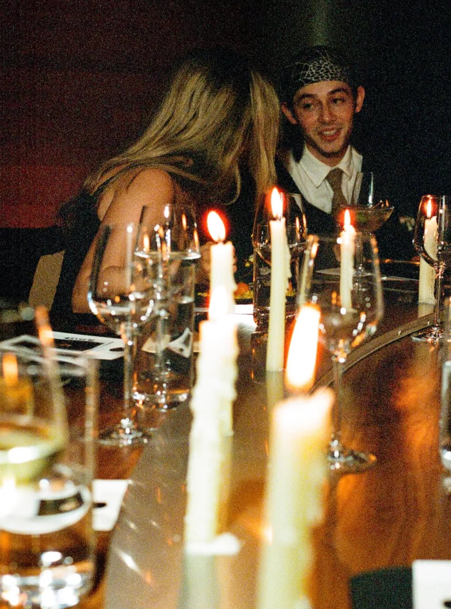 Two guests talking over a candlelit table
